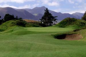 un campo de golf verde con montañas al fondo en Glencurrah House B&B, en Glenbeigh