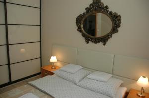 a bedroom with a bed and a mirror on the wall at Apartament Przy Promenadzie in Świnoujście