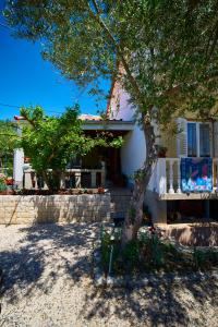 ein Haus mit einem Baum davor in der Unterkunft Balen Guest house in Rab