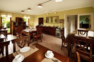 a kitchen and dining room with wooden tables and chairs at Hullám Villa B&B in Balatonmáriafürdő