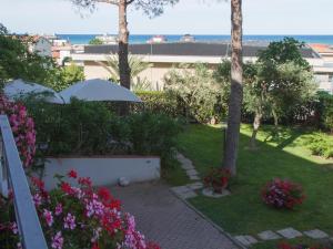 Blick auf einen Garten mit Blumen und einem Sonnenschirm in der Unterkunft Il Sestante in Civitanova Marche