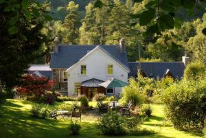 a large white house in the middle of a yard at Rosebank House Bed & Breakfast in Strathyre