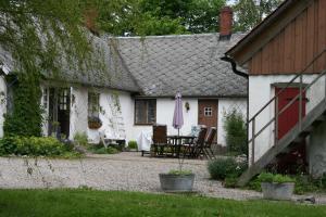 a white house with a patio and a table and chairs at Karlsborg Rum och Frukost in Ystad