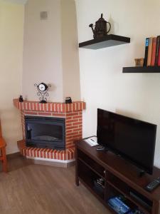 sala de estar con chimenea y TV de pantalla plana en Plaza Principal Zahara - MAGNIFICA UBICACION y VISTAS en Zahara de la Sierra