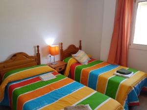 1 dormitorio con 2 camas y sábanas coloridas en Plaza Principal Zahara - MAGNIFICA UBICACION y VISTAS en Zahara de la Sierra