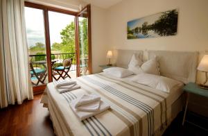 a bedroom with a large bed and a balcony at Hullám Villa B&B in Balatonmáriafürdő +82 photos