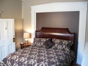 uma cama com uma cabeceira em madeira num quarto em Cumberland Inn and Spa em Cumberland