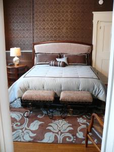 Cumberland Inn and Spa في كمبرلاند: غرفة نوم بسرير كبير مع اللوح الخشبي