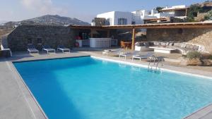 ein großer Pool mit Stühlen und ein Haus in der Unterkunft Otherview Villa in Super Paradise Beach