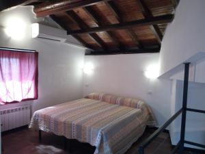 sypialnia z łóżkiem w pokoju z oknem w obiekcie Villino "Il Rustichetto" w Genui