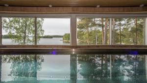 a house with a swimming pool with a view of a lake at Hotelli Salpa in Luumäki