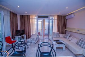 uma sala de estar com um sofá e cadeiras e uma televisão em Apartment Magnolia Rustaveli 62 em Batumi