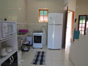 a kitchen with two refrigerators and a stove at Chalé no Caborê in Paraty