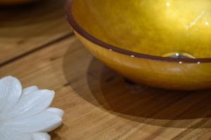 a yellow bowl and a white flower on a wooden table at Casa delle More in Civitaquana