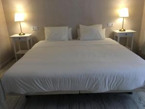 カディスにあるCasa Bugambilla Cadizの白い大型ベッド(両側にランプ2つ付)