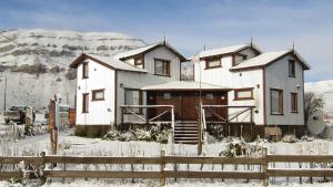 una casa nella neve con una recinzione di Cabañas Alechen a El Calafate