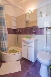a bathroom with a toilet and a tub and a sink at Apartment Riva 5 in Komiža
