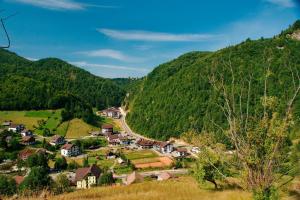 ein kleines Dorf in einem Tal mit Bergen in der Unterkunft Resort Cheile Gradistei Moieciu in Moieciu de Sus