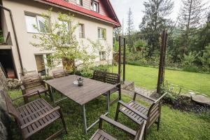 a wooden table and chairs in the yard of a house at Villa Kokosowa in Wisła