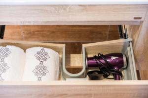 uma gaveta de madeira com toalhas e uma chávena roxa em Golden Star Motel em Christchurch