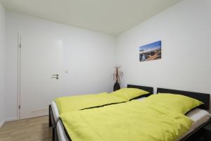 a bed with a yellow comforter in a bedroom at Berlin City Apartments in Berlin