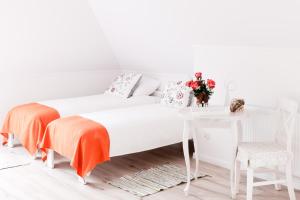 ウクタにあるRezydencja Pod Taborskimi Sosnamiの白いベッドルーム(ベッド1台、テーブル付)
