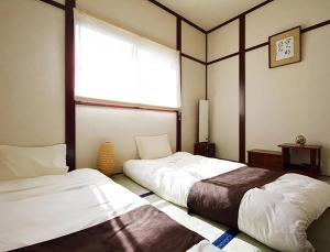 two beds in a room with a window at City Hotel Universal Studios Japan in Osaka