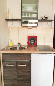 a small kitchen with a sink and a microwave at Mia Airport studio apartment in Velika Gorica