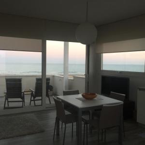 una sala da pranzo con tavolo, sedie e vista sull'oceano di Un angolo di mare a Pozzallo
