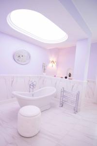 a white bathroom with a tub and a sink at Il Giardino delle Jacaranda in Talsano