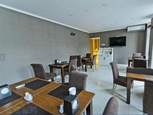 a dining room with tables and chairs and a tv at Sea Towers 2 room apartment in Batumi
