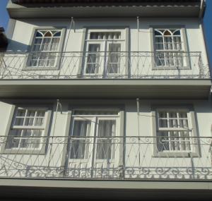 a white building with windows and a balcony at Vila Baixa - alojamento local in Guimarães