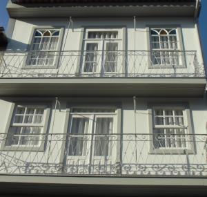 Edificio blanco con ventanas y balcón en Vila Baixa - alojamento local, en Guimarães