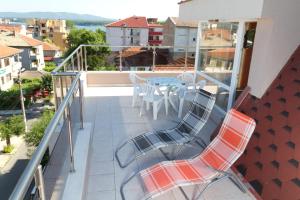a balcony with a table and chairs on it at Guest House Dobi in Primorsko
