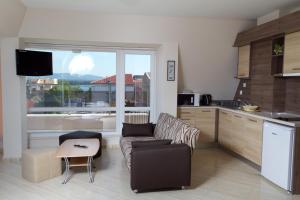 a kitchen and living room with a couch and a table at Guest House Dobi in Primorsko