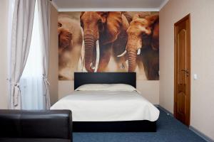 a bedroom with a mural of elephants on the wall at Gostinitsa DmitrovGrad in Dmitrov