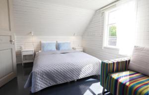 a bedroom with a bed and a window and a chair at Käsmu Võrkneeme Apartments in Käsmu