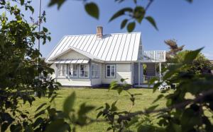 a small white house on a grassy field at Käsmu Võrkneeme Apartments in Käsmu
