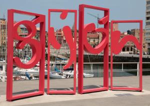 een rood bord waarop staat: vertrek op een pier bij Hostal Libertad in Gijón