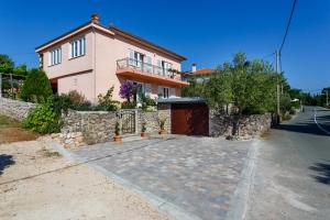 a house with a stone wall and a driveway at Apartmani Anica in Risika