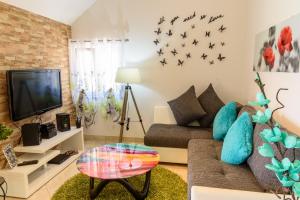 a living room with a couch and a tv at Villa Lucija Bol in Bol