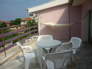 - Balcón con mesa y sillas y hamaca en Hotel Strajica en Lozenets