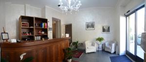 a lobby with a reception desk and chairs and a chandelier at Hotel Giulio Cesare in Turin