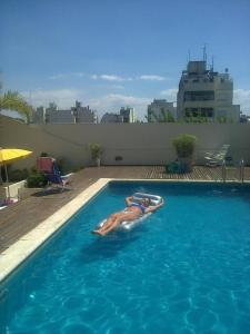 una mujer tumbada en una balsa en una piscina en La Casa De Lily en Buenos Aires
