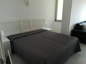 een slaapkamer met een groot bed en een zwarte deken bij Tres Castelos Apartamento 1203 in Portimão