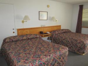 a hotel room with two beds and a table at Bonanza Gold Motel in Dawson City