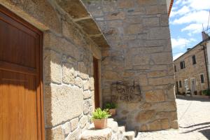 un edificio de piedra con una puerta y una planta. en Alojamento Rural Casa da Eira, en Murça