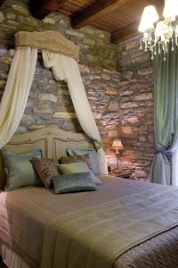 a bedroom with a bed with a stone wall at Hotel Minelska Resort in Kala Nera