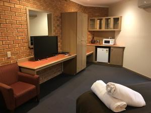 a room with a desk with a computer and a chair at Eltham Motor Inn in Eltham