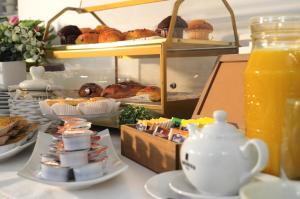 a table with plates of food and a jug of orange juice at Hotel Giulio Cesare in Turin